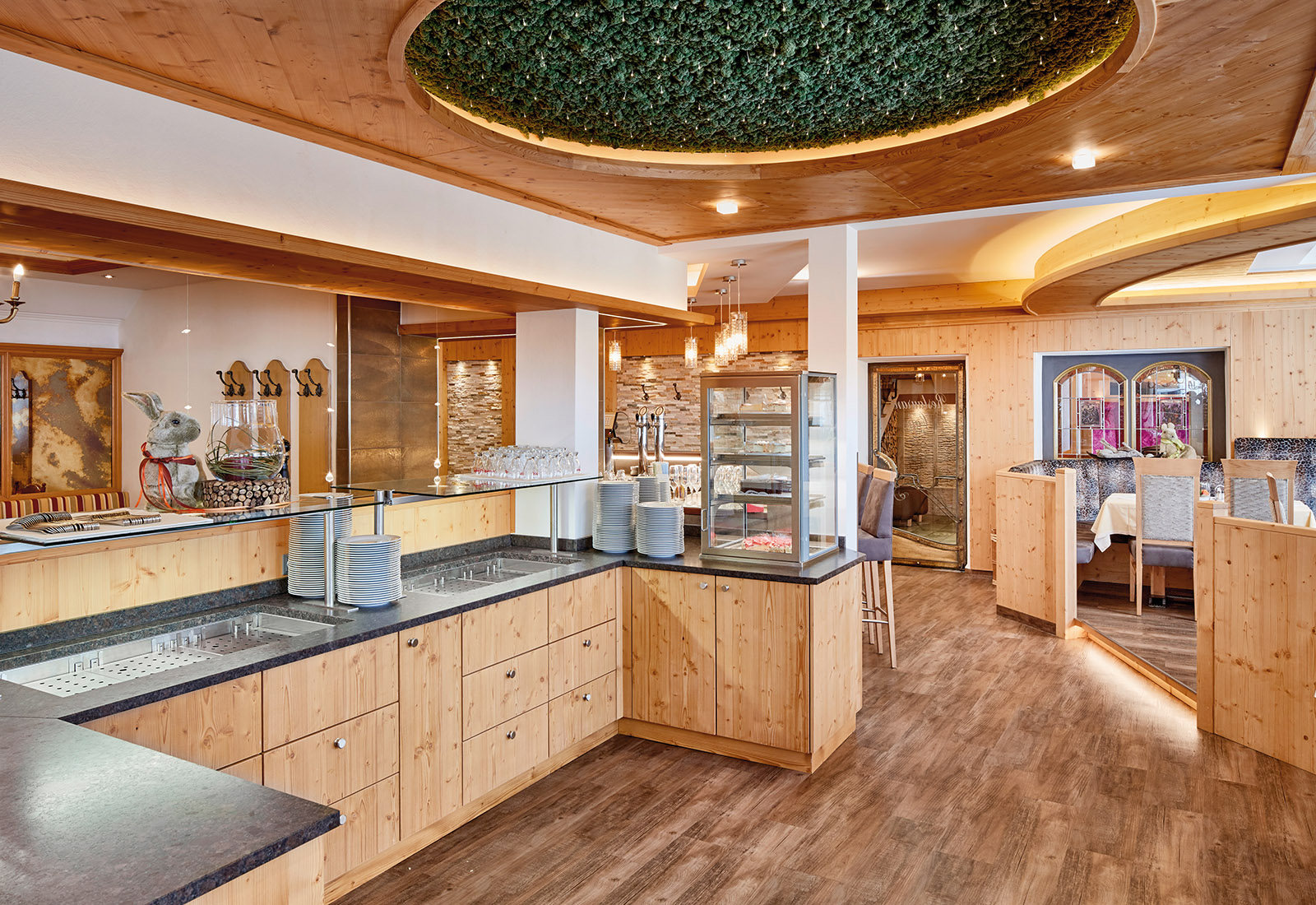 Restaurantbereich mit Buffetstation, Holzinterieur und moderner Beleuchtung